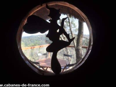Cabane perchée en Auvergne-Rhône-Alpes, silhouette féerique à la fenêtre.