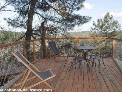 Cabane perchée en Auvergne-Rhône-Alpes avec terrasse en bois et vue dégagée sur la nature.