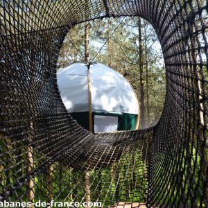 Hébergement insolite en Aquitaine : yourte suspendue entourée de verdure.