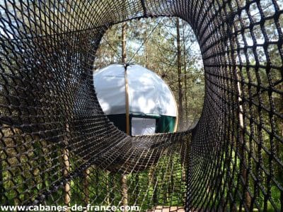 Hébergement insolite en Aquitaine : yourte suspendue entourée de verdure.