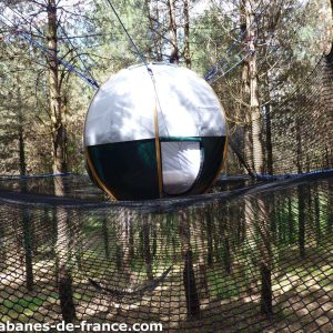 Hébergement insolite en Aquitaine : bulle suspendue dans les arbres, entourée de filets.
