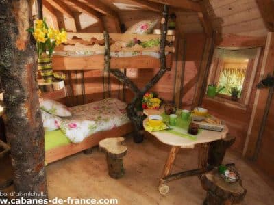 Cabane en bois cosy avec lit en mezzanine et décor floral, située en Grand-Est.