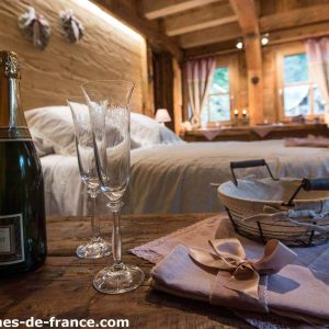 Cocon romantique en cabane, avec champagne et décor en bois chaleureux.
