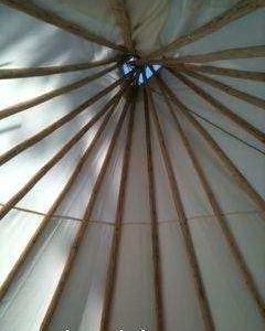 Intérieur dun tipi en Auvergne-Rhône-Alpes, avec vue sur le ciel à travers louverture.
