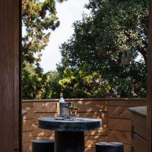 Cabane perchée en Languedoc-Roussillon avec une terrasse et une table en pierre.