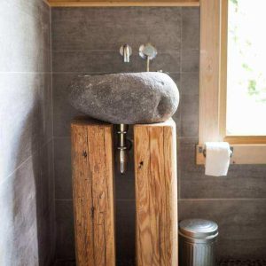 Lavabo en pierre sur support bois dans un hébergement insolite en Languedoc-Roussillon.