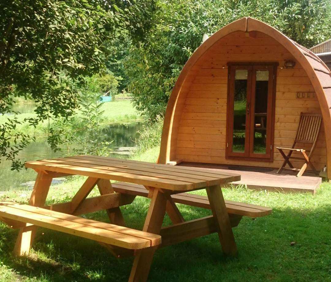 Cabane en bois au bord de leau, avec une table de pique-nique en plein air.