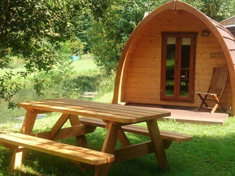 Cabane en bois au bord de leau, avec une table de pique-nique en plein air.
