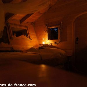 Cabane en bois cosy en Auvergne, éclairée par une douce lumière tamisée.