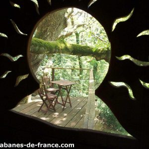 Cabane perchée en Bretagne avec une vue sur la nature et une terrasse en bois.