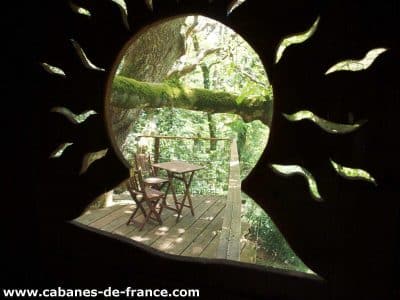 Cabane perchée en Bretagne avec une vue sur la nature et une terrasse en bois.