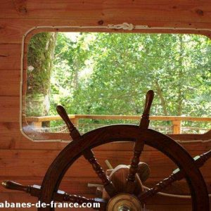 Cabane en bois en Bretagne avec vue sur la nature et un grand gouvernail.