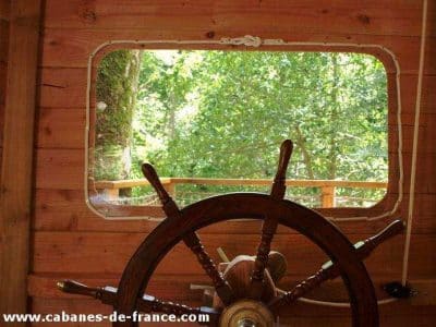 Cabane en bois en Bretagne avec vue sur la nature et un grand gouvernail.