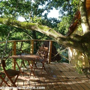 Cabane dans les arbres en Bretagne, avec terrasse en bois et vue sur la nature.