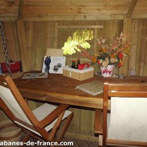 Cabane en bois en Bretagne, avec un bureau en bois et des décorations florales.