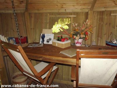 Cabane en bois en Bretagne, avec un bureau en bois et des décorations florales.