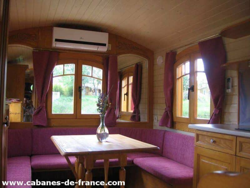 Cabanes en bois dans les montagnes, intérieur chaleureux avec fenêtres et coin repas.