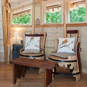 Intérieur chaleureux dune cabane en bois avec chaises confortables et table en bois.