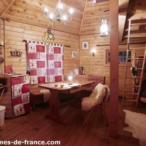 Cabane en bois à Champagne-Ardennes, avec un intérieur chaleureux et une table en bois.