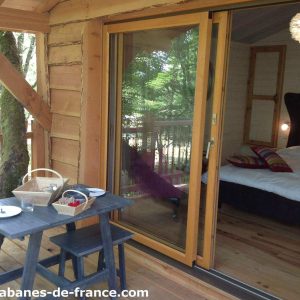 Cabane perchée en Aquitaine, avec vue sur la nature et terrasse en bois.