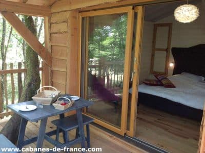 Cabane perchée en Aquitaine, avec vue sur la nature et terrasse en bois.