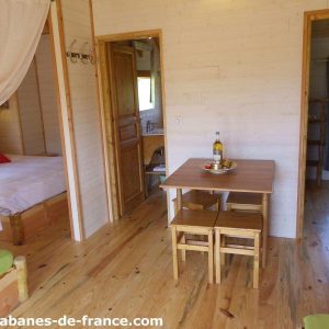 Cabane en bois en Aquitaine, avec un intérieur chaleureux et une table en bois.