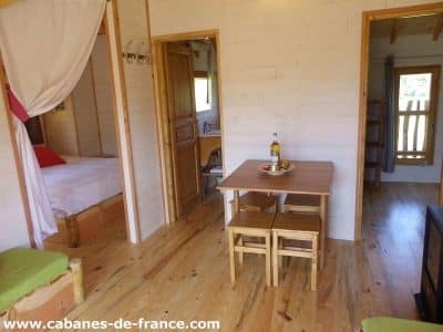 Cabane en bois en Aquitaine, avec un intérieur chaleureux et une table en bois.