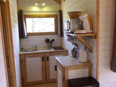 Cabane en bois en Aquitaine, avec cuisine équipée et lumière naturelle.