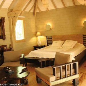 Cabane en bois moderne avec lit king-size et décoration chaleureuse à Languedoc-Roussillon.