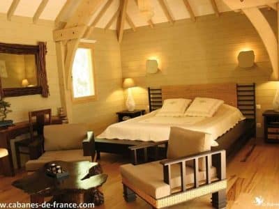 Cabane en bois moderne avec lit king-size et décoration chaleureuse à Languedoc-Roussillon.