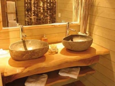 Salle de bain en bois avec vasques en pierre, hébergement insolite en Languedoc-Roussillon.