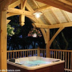 Cabane en bois avec jacuzzi, offrant une vue apaisante sur la nature environnante.