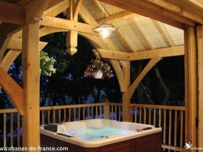 Cabane en bois avec jacuzzi, offrant une vue apaisante sur la nature environnante.