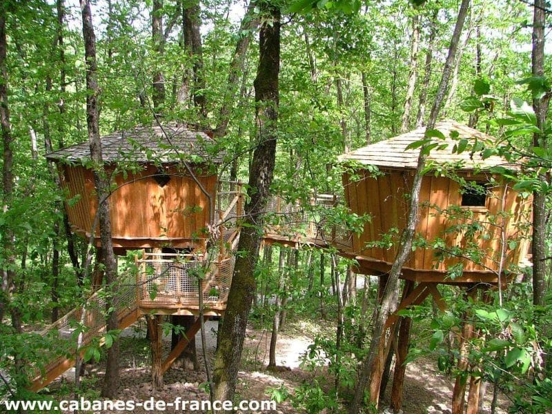 Cabane dans les arbres en Auvergne-Rhône-Alpes, nichée parmi la verdure luxuriante.