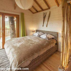 Cabane en bois en Aquitaine, avec un lit douillet et des touches de bambou.