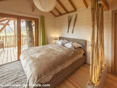 Cabane en bois en Aquitaine, avec un lit douillet et des touches de bambou.