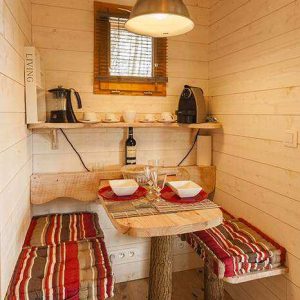 Cabane en bois cosy en Aquitaine, avec table en rondins et décor chaleureux.