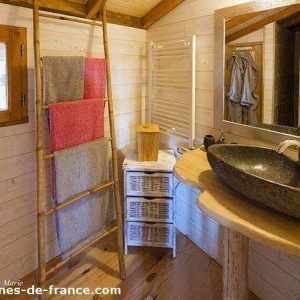 Cabane en bois en Aquitaine avec un lavabo en pierre et des serviettes colorées.