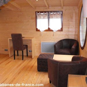 Cocon en bois à Pays de la Loire, avec fauteuils confortables et décor chaleureux.