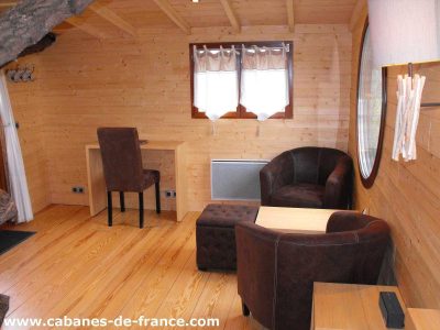 Cocon en bois à Pays de la Loire, avec fauteuils confortables et décor chaleureux.