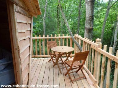 Cabane perchée en Aquitaine avec terrasse en bois et vue sur la forêt.