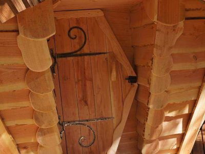 Cabane en bois dans les arbres en Auvergne, avec une porte en fer forgé décorative.
