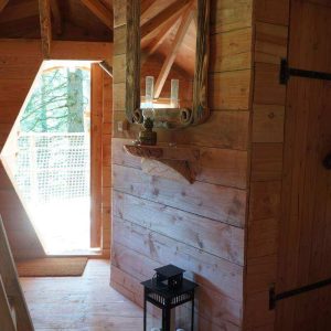 Cabane en bois en Auvergne, avec un miroir en bois et une lanterne décorative.