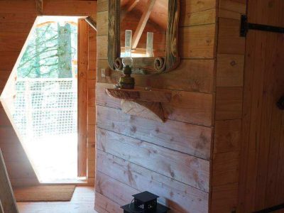 Cabane en bois en Auvergne, avec un miroir en bois et une lanterne décorative.