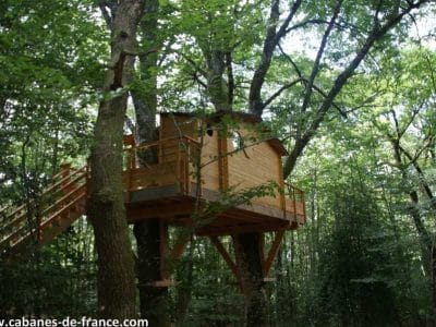 Cabane dans les arbres en Midi-Pyrénées, perchée au cœur dune forêt verdoyante.