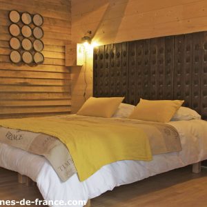 Chambre en cabane boisée avec un lit douillet et des accents rustiques.