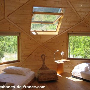 Cabanes en bois avec grandes fenêtres, offrant une vue sur la nature en Auvergne-Rhône-Alpes.