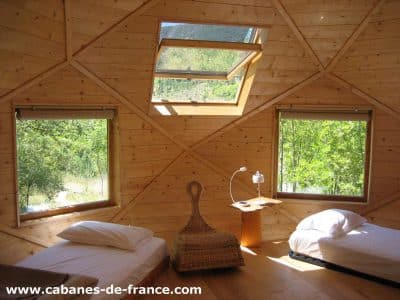 Cabanes en bois avec grandes fenêtres, offrant une vue sur la nature en Auvergne-Rhône-Alpes.
