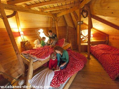 Chalet en bois chaleureux avec lits à baldaquin et décor coloré. Parfait pour familles.