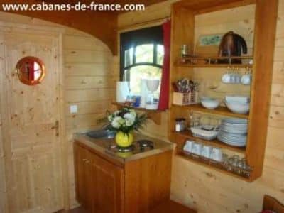 Intérieur chaleureux dune cabane en bois, avec kitchenette et décor naturel.